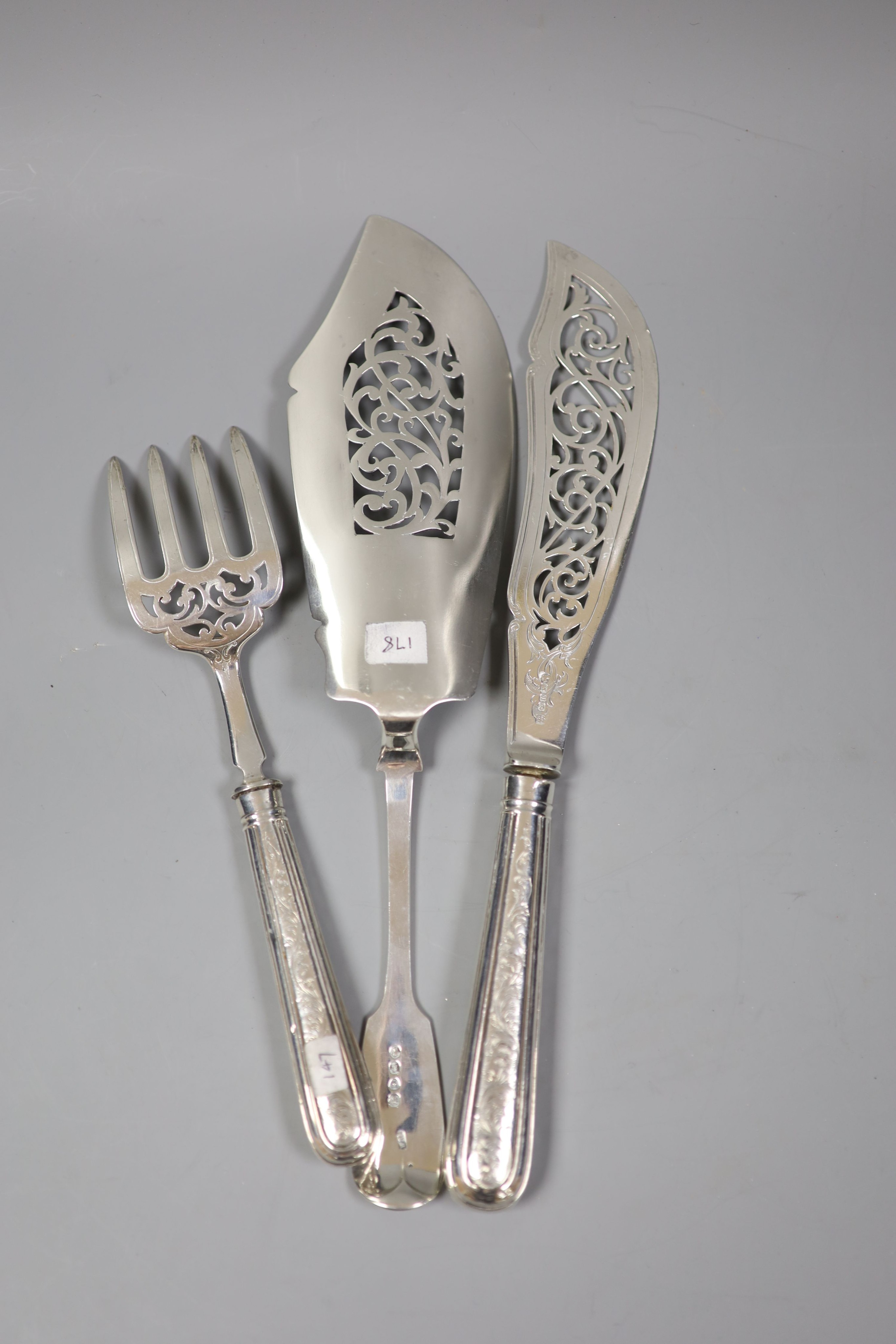 A pair of Victorian silver fish servers with loaded handles, Sheffield, 1853 and a Victorian silver fiddle pattern fish slice.